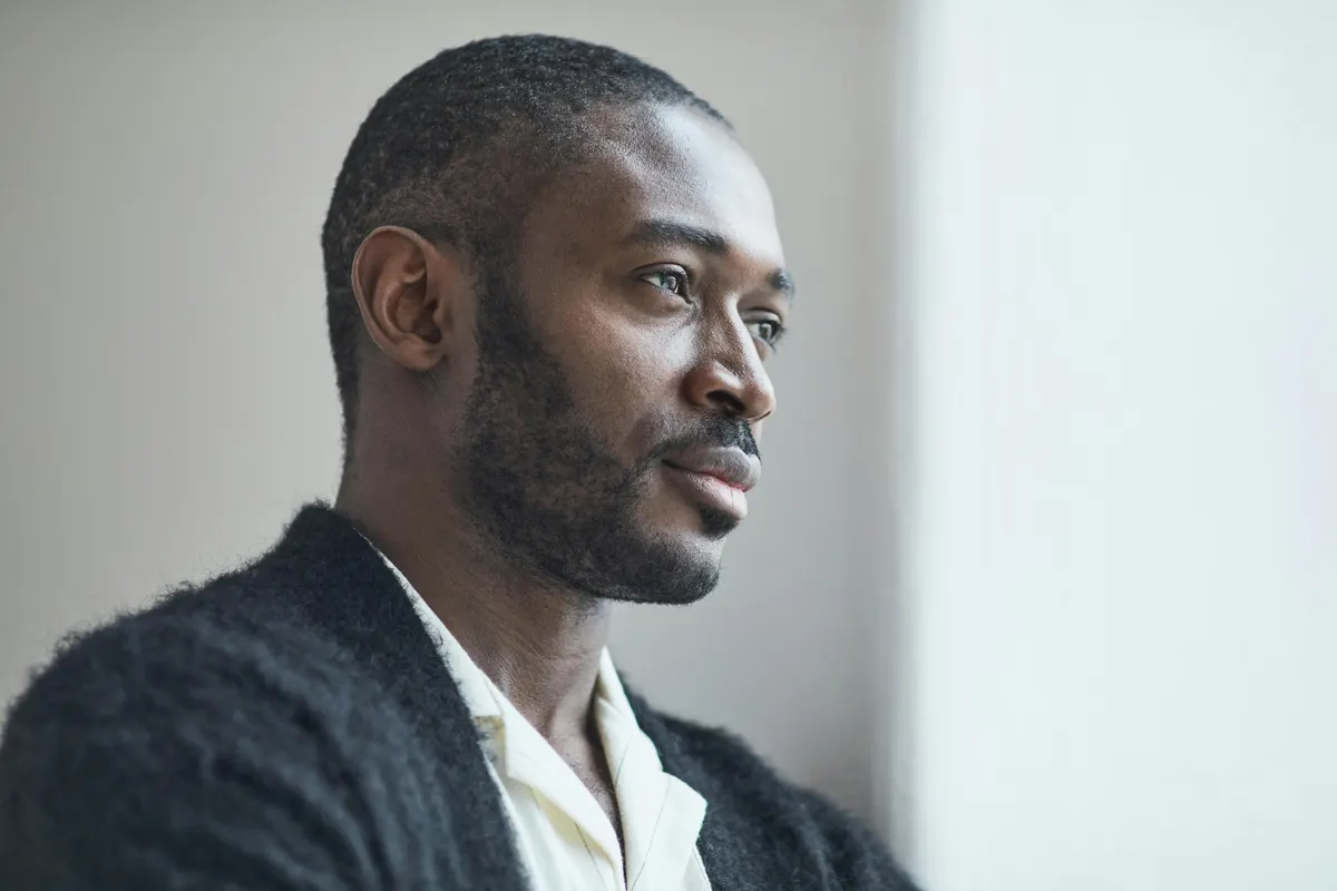 Thoughtful man in profile, standing by a window